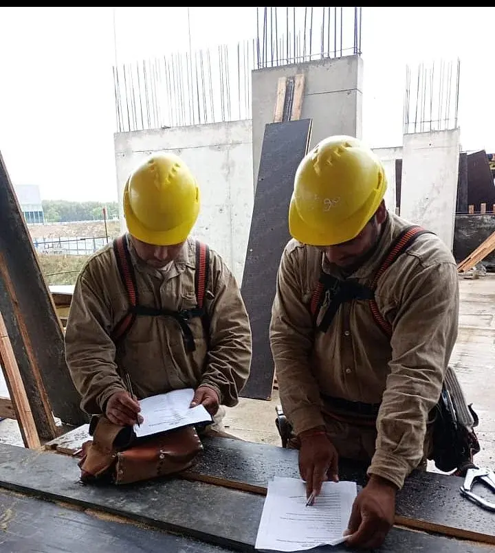 Operarios de obra completando documentación de seguridad junto a SM Consultora