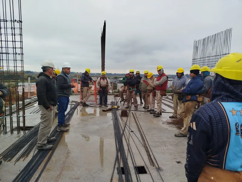 Charla de seguridad a una cuadrilla en una losa de obra en construcción
